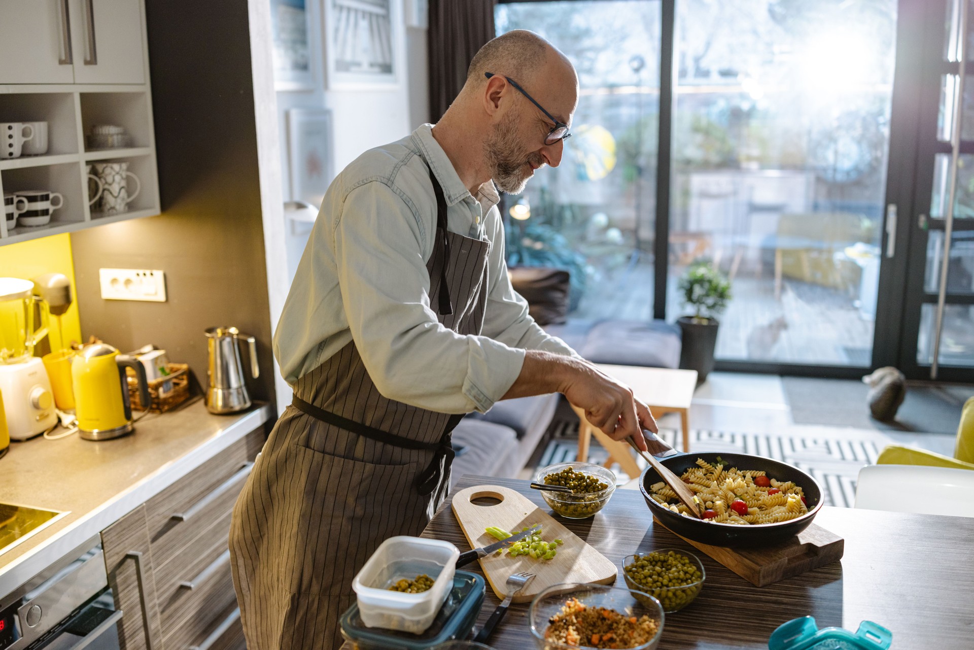 Mature man preparing a healthy pasta meal in a nonstick pan